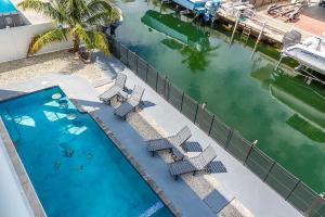 an overhead view of a pool with chairs and the water at Tipsy Turtle - Waterfront Pool Home, Direct Atlantic Access! in Marathon
