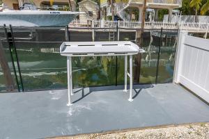 a white table sitting next to a body of water at Tipsy Turtle - Waterfront Pool Home, Direct Atlantic Access! in Marathon