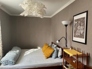 een slaapkamer met een bed met gele kussens en een lamp bij Apartment on Knyahyni Ol'hy Street in Rivne