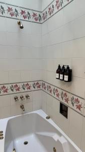 a bath tub in a bathroom with flowers on the wall at CasaCharcas Hotel Boutique in San Salvador de Jujuy +31 photos