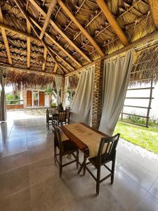 a dining room with a wooden table and chairs at Pousada Flor dos Buritis in Paulino Neves +16 photos