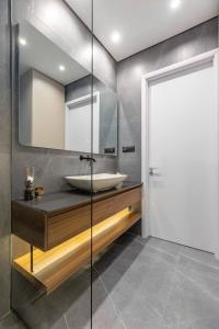 a bathroom with a sink and a mirror at Апартаменты с двумя спальнями и собственной террасой на крыше в доме с бассейном, возле пляжа Яз in Budva