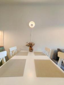 a dining room table with a vase of flowers on it at Apartament VerdeMar in Rowy +5 photos