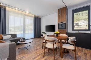 a living room with a couch and a table at Апартаменты с двумя спальнями и собственной террасой на крыше в доме с бассейном, возле пляжа Яз in Budva