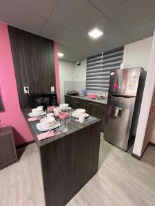 a kitchen with a counter with plates and a refrigerator at Moderno, en el centro de La Paz in La Paz +7 photos