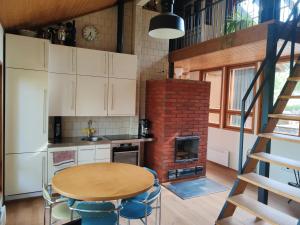 a kitchen with a table and a brick oven at Villa Tammio in Uusikaupunki