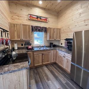 a kitchen with wooden cabinets and a stainless steel refrigerator at Dragonfly Nest, cabin vibe, river views in Fountain City