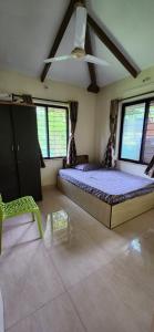 a bedroom with a large bed and a green chair at Gulmohar Villa tamhini ghat, Kolad Rafting  +21 photos