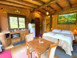 a bedroom with a bed and a table in a room at Cabana com vista para o canyon in Praia Grande