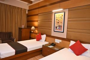 una habitación de hotel con dos camas y una silla en Hotel Broadway, en Chandīgarh 22 fotos más