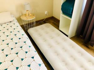 a bedroom with two twin beds and a table at Gîte Clair de Lune in Monts-sur-Guesnes +23 photos