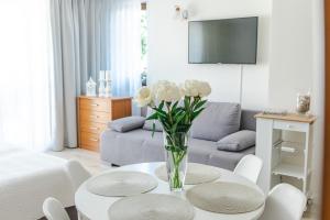 a living room with a vase of flowers on a table at Kamea in Pobierowo