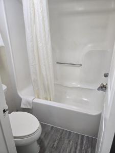 een witte badkamer met toilet en douche bij Studios 4 Less Chesapeake in Chesapeake