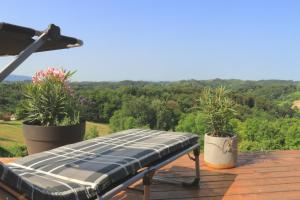 a bench on the deck of a house with a view at Relaxing Tiny House with a beautiful view over the hills in Zagorje in Bedekovčina