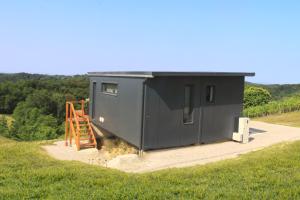 a rendering of a black tiny house in a field at Relaxing Tiny House with a beautiful view over the hills in Zagorje in Bedekovčina