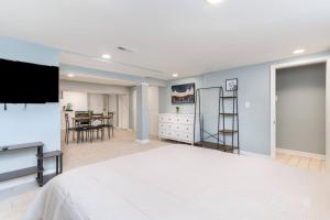 a bedroom with a large bed and a flat screen tv at Cozy Basement Studio Retreat Dundalk in Dundalk