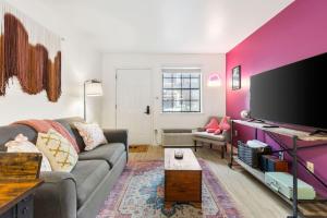 a living room with a couch and a flat screen tv at Pink Dreams - Walk to Live Music, Bars, Restaurants - Free Parking in Nashville