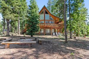 a log home with a deck and picnic tables in front of it at Mallard Manor Hot Tub in Duck Creek Village