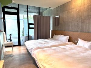 una camera da letto con un grande letto bianco e una sedia di 小憩宜蘭包棟丨寵物友善丨烤肉丨Ktv a Dongshan