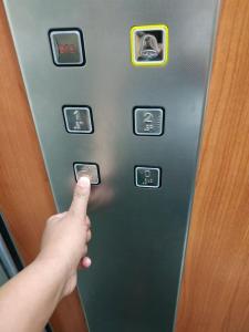 una persona pulsando un botón en un ascensor en Cozy, Romantic Studio next to The Mall, en Atenas