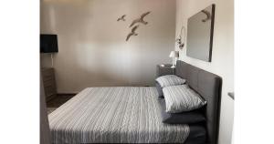 a bedroom with a bed and a chair with birds on the wall at Villa Anna in Messina