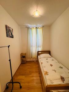 ein kleines Schlafzimmer mit einem Bett und einem Fenster in der Unterkunft Charming Hill Apartment in Opatija