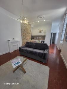 un salon avec un canapé noir et une table dans l'établissement Grand T2 Cours Napoleon B, à Ajaccio