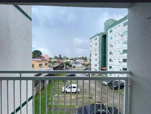 un balcón con vistas a un aparcamiento con coches en Apartamento cop 30 ainda será mobiliado, en Ananindeua