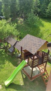 une table de pique-nique avec un toboggan vert et une aire de jeux dans l'établissement Домашній затишок, à Slavsko