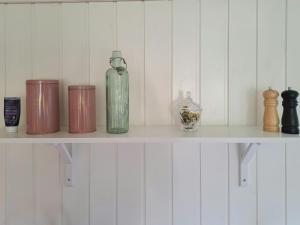 a shelf with bottles and other items on it at Cottage Charm Near Lønstrup Lighthouse in Lønstrup