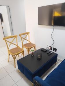 una sala de estar con una mesa y dos sillas en Grace Villas 2, en East London