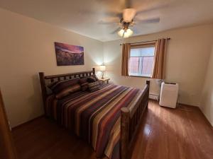 a bedroom with a large bed and a fan at Sun Outdoors Yellowstone North in Gardiner