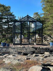 un cenador negro sentado en una pared de piedra en Cozy Cabin With Sea View And Two Terraces, en Tjøme