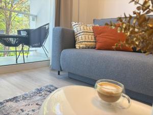 salon z kanapą i filiżanką kawy na stole w obiekcie Lucky40 - Apartament z widokiem na morze, SPA gratis, Dwie Sosny w mieście Ustronie Morskie +37 zdjęć