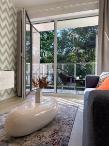salon z dużym oknem i białym stolikiem kawowym w obiekcie Lucky40 - Apartament z widokiem na morze, SPA gratis, Dwie Sosny w mieście Ustronie Morskie