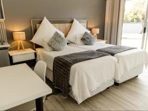 a bedroom with two beds with white sheets and pillows at Alte Welkom Guesthouse in Klerksdorp +17 photos