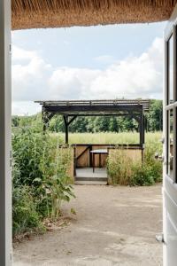 an open doorway to a building with a thatched roof at Nostalgic Charm In A Yellow Timber House in Sakskøbing