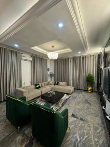 Una sala de estar con un sofá y un televisor. en Luxury 3 Bedroom Bungalow at Golf Estate, en Enugu