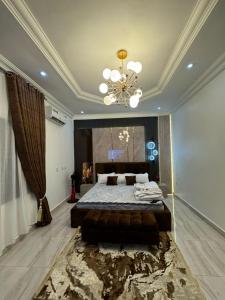 Un dormitorio con una cama grande y una lámpara de araña. en Luxury 3 Bedroom Bungalow at Golf Estate, en Enugu