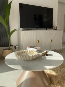 a white coffee table in a living room with a tv at Apartament Echo Park in Olecko