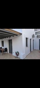 een grote witte kamer met een tafel en een stoel bij Thea Marina ! in Livadion