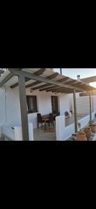 een patio met witte stoelen en een houten parasol bij Thea Marina ! in Livadion