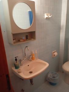 a bathroom with a sink and a mirror and a toilet at THE PALM ROOMs in Preveza