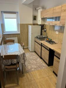 a kitchen with a table and a white refrigerator at Studio 1 & Studio 2 Aqua in Eforie Nord +1 photo