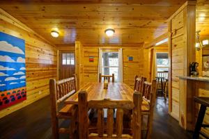 Un comedor con mesa y sillas de madera. en Outlaw Rose Cabin - Family Fun with Hot Tub, en Broken Bow