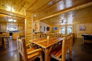 comedor de madera con mesa y sillas de madera en Outlaw Rose Cabin - Family Fun with Hot Tub, en Broken Bow