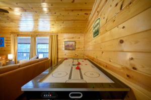 Una habitación con una mesa de póquer en una cabaña de madera. en Outlaw Rose Cabin - Family Fun with Hot Tub, en Broken Bow