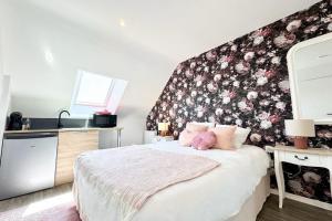 a bedroom with a bed with a floral accent wall at L’instant rose - Cocon fleuri avec jacuzzi in Quéven
