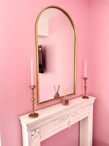 a mirror on top of a white table with two candles at Studio rose & spa Pause bien-être in Quéven