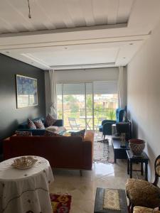 a living room with a couch and a table at Appartement Kettani bouznika in Bouznika